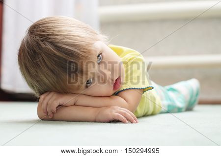 Little Caucasian girl lying on the floor on arms