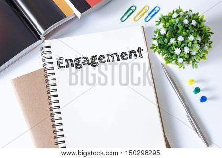 engagement word message on white paper book and copy space on white desk / business concept / top view