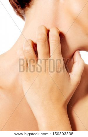 Topless woman scratching her neck.