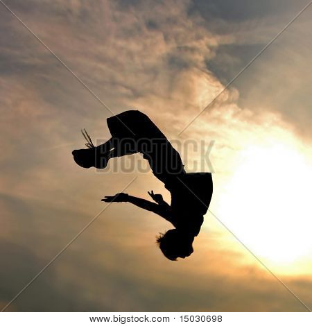 silhouette di saltare l'uomo contro il cielo e le nuvole