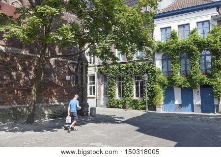 Ghent, 27 august 2016: man walks with water bottles in old picturesque part in Patershol in centre of ghent in belgium