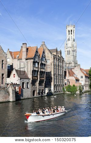 Maarssen, Netherlands, 30 september 2016: old houses and tourist boat in canal in centre of medieval Brugge in Belgium with blue sky in summer