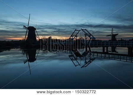 Colorful autumn scene in the famous Kinderdijk canals with windmills. Sunset in Dutch village Kinderdijk Netherlands Europe. UNESCO world heritage site.