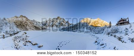Winter day in Polish Tatra mountains, frozen Morskie Oko lake and summits in the clouds.