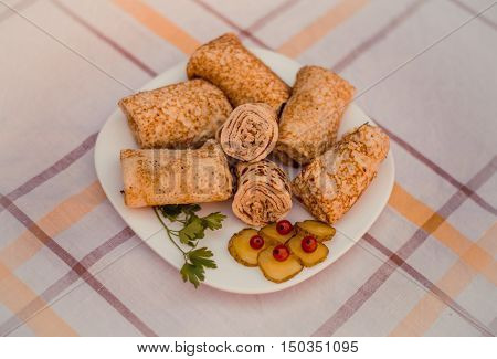 Tasty pancakes with meat on white plate closeup. Crepes stuffed with finely cut meat.