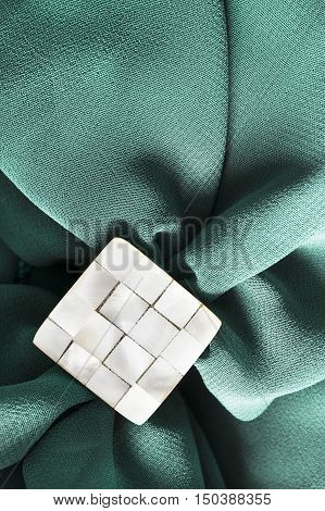 Nacre brooch on crumpled blue silk as a background
