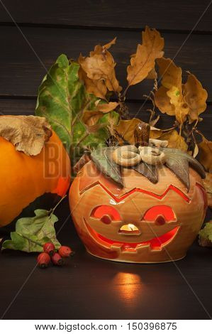 Halloween pumpkin party, Big terrible Pumpkin lighten and reflection on wooden table background. Halloween pumpkin with scary face. Place for your text.