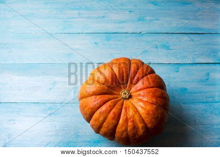 Ripe pumpkins on the blue wooden background. Thanksgiving background with pumpkin. Fall background. Copy space.