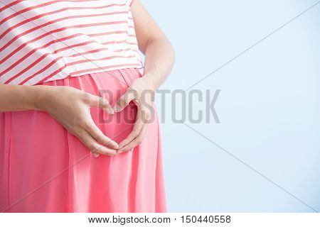 pregnant woman is smile isolated on bluebackground asian