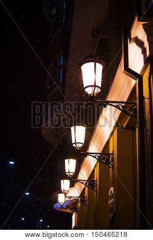 Lit up street lamp at rainy night close up