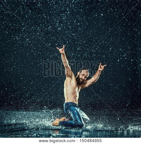 The male break dancer in water on dark background.