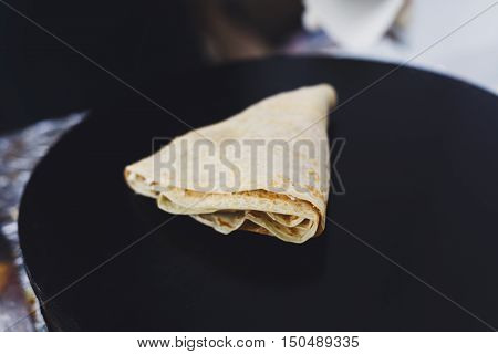 Making ham and cheese crepe at pan. Salty crepe or pancake with fillings made by street vendor's hands at outdoors creperie. French cuisine, cooking for commercial kitchen.