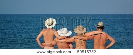 Family in hats standing on the beach