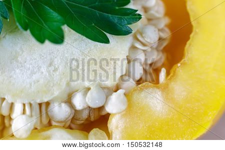 The fruit of yellow bell pepper cut lengthwise visible core of fruit and seeds. Presents closeup.
