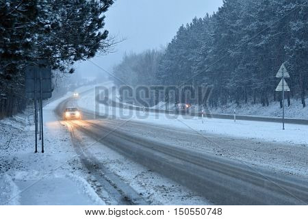 Cars in the fog. Bad winter weather and dangerous automobile traffic on the road. Light vehicles in fog.