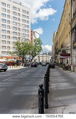 WARSAW POLAND - JUNE 11 2016: The view along the street named Zgoda in the city center. Along the street was set metal bars separating the sidewalk from the roadway.