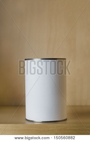 One single tin can (aluminum) with blank white label on shelf with copy space above.