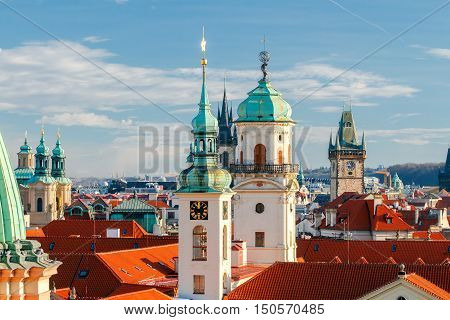Aerial view of the historic center of Prague with towers, spiers and red-tiled roofs.