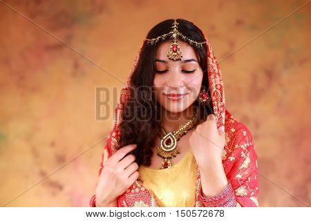 beautiful Indian woman in a sari traditional dress on an abstract yellow background