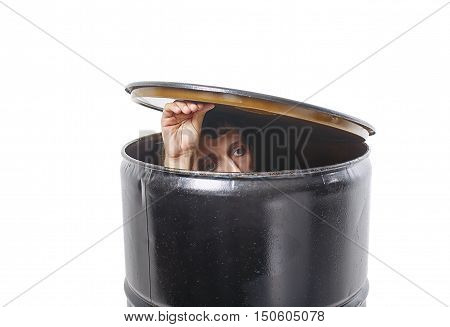 young man hides in a barrel. guy lifted the lid barrels and looks cautiously. the concept of avoiding problems. isolated on white background.