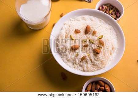 Indian sweet sutarfeni or sutar feni or firni or seviyan or laccha, shredded, flaky-rice-flour roasted in ghee, blended with melted sugar to form a cotton candy, topped with pistachio and almonds