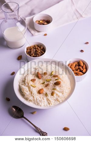 Indian sweet sutarfeni or sutar feni or firni or seviyan or laccha, shredded, flaky-rice-flour roasted in ghee, blended with melted sugar to form a cotton candy, topped with pistachio and almonds