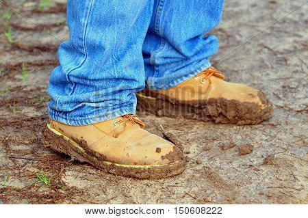 Trekking shoes coated with mud after a walking trip on a winters day.