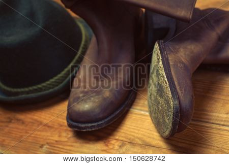 American West rodeo cowboy dirty and used brown botts and hat