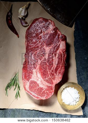 veal steak marbled paper, knife for meat, rosemary, pepper and salt