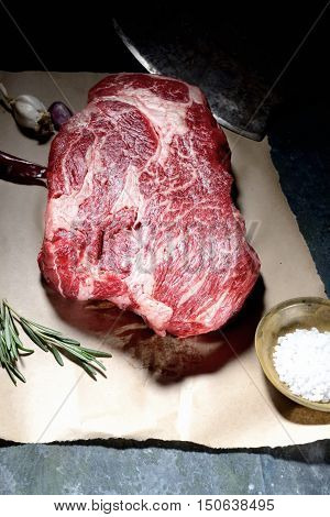 veal steak marbled paper, knife for meat, rosemary, pepper and salt