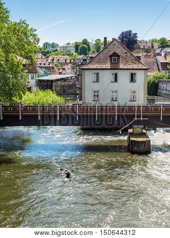 Bamberg Germany - May 22 2016: Canoeist on the River Regnitz against the background of the bridge and the architecture of the old town of Bamberg Bavaria Germany Europe.