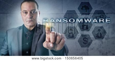 Mature cyber investigator is touching RANSOMWARE onscreen. information technology concept and cyber security metaphor malicious software that restricts data access to extortionate ransom money.