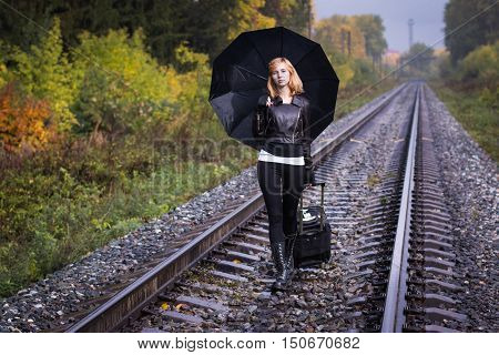 Girl, Umbrella And Rails In Autumn Day
