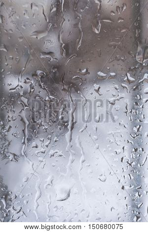 Running down the opaque window drops of water.