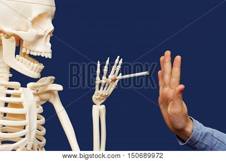 Death offers man a cigarette. Person raised his hand in a negative gesture. Person avoiding smoking.