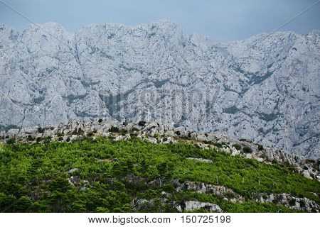 Beautiful mountain ranges with high peaks natural elevation of earth surface on blue sky background with green nature