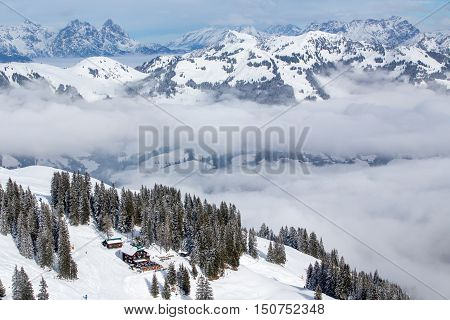 Tyrolian Alps covered by fresh snow in fog seen from the Kitzbuehel ski resort Austria