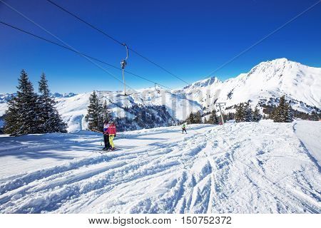KITZBUEHEL AUSTRIA February 17 2016 - Skiers on ski lift enjoying the view to foggy Alps in Austria and beautiful snowy country panorama in famous Kitzbuehel mountain ski resort