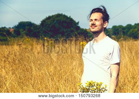 Man Standing In Field Of Dry Grass