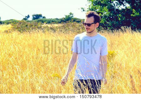 Man Standing In Field Of Dry Grass