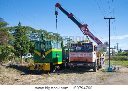 DALAT, VIETNAM - DECEMBER 27, 2015: Renovation of the locomotive with the aid of the crane on the chassis of Russian Kamaz-64112 car at the railway station of Dalat city