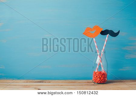 Valentine's day romantic background. Retro bottle and strows with paper mustache and lips.