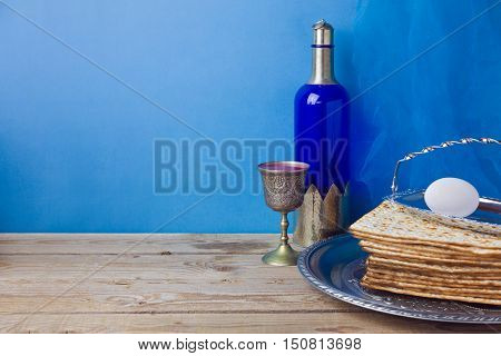Passover background with wine matzoh and egg over blue wall