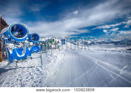 Snow cannons with fresh prepared ski slopes with the corduroy pattern in Kitzbuehel ski resort.