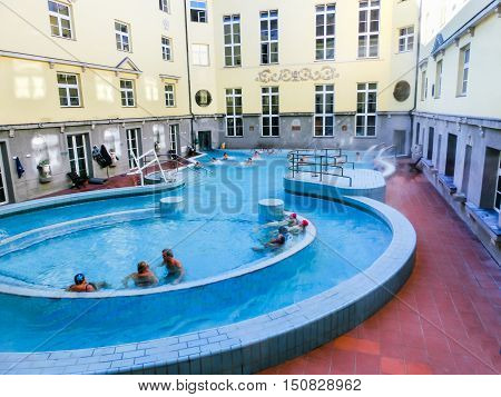 Budapest, Hungary - January 07, 2016: Tourists enjoy at the Lukacs Bath, at historic outdoor thermal bath heated naturally by hot springs, in Budapest, Hungary.