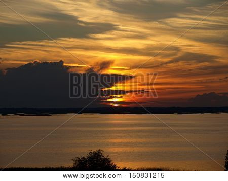 Sunset on a cloudy summer evening by the lake