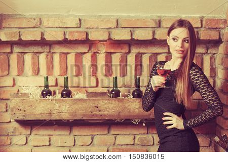 Woman Tasting Wine In Rural Cottage Interior