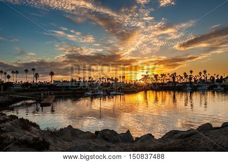 Reflected sunrise clouds in Ventura Marina water at dawn.