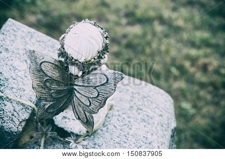 Back view of an angel statue in a cemetary with faded effect
