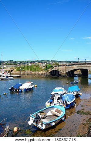 AXMOUTH, UNITED KINGDOM - JULY 18, 2016 - Fishing boats moored in the harbour with the stone bridge to the rear Axmouth Devon England UK Western Europe, July 18, 2016.